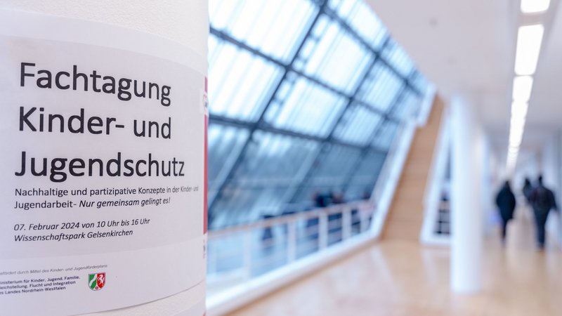 Eine Säule mit der Ankündigung des Fachtages auf der Etage eines Gebäudes. Der Hintergrund ist gesoftet.